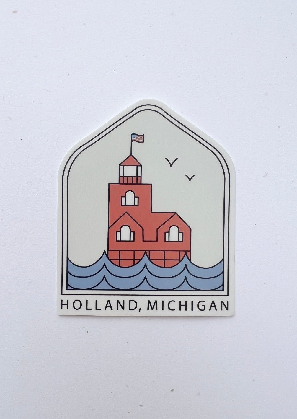 Arched sticker displaying big red lighthouse and water with the words Holland Michigan on it.
