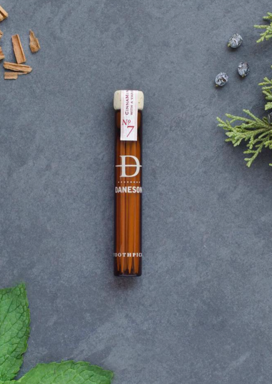 Glass bottle with toothpicks inside it.