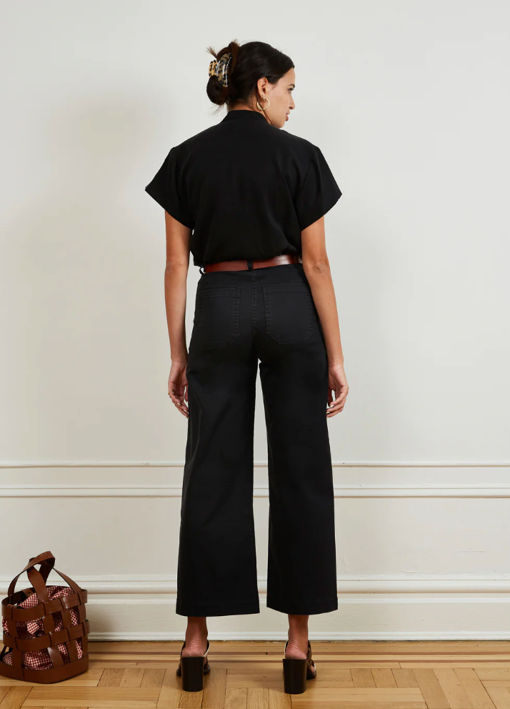 Women in black top and black, high-waisted, wide leg jeans