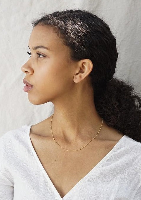 Woman wearing delicate gold necklace
