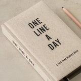 One Line a Day journal laying on a table with a pen.